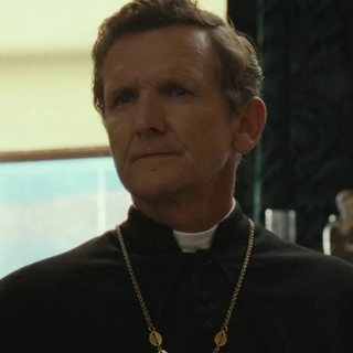 Father Renaud as seen in the show, played by Sebastian Roché